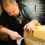 Chef Angelo Galasso opening Parmigiano Reggiano