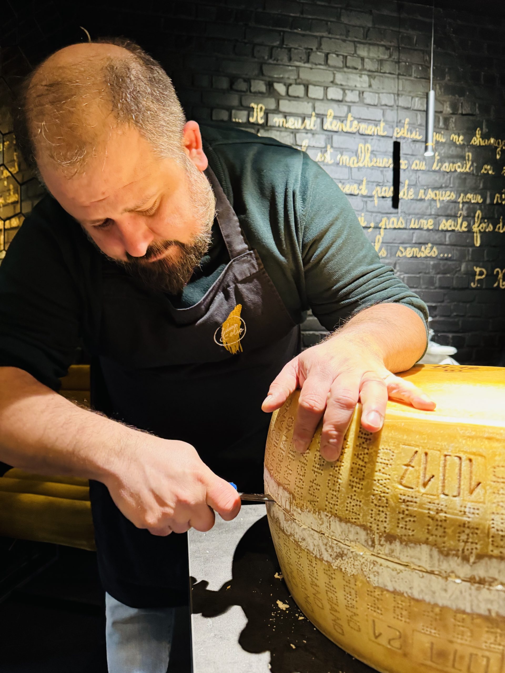 Chef Angelo Galasso opening Parmigiano Reggiano